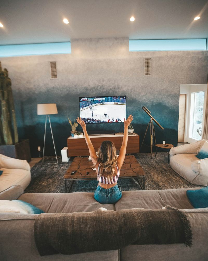 Viewer cheering in front of a large television at home